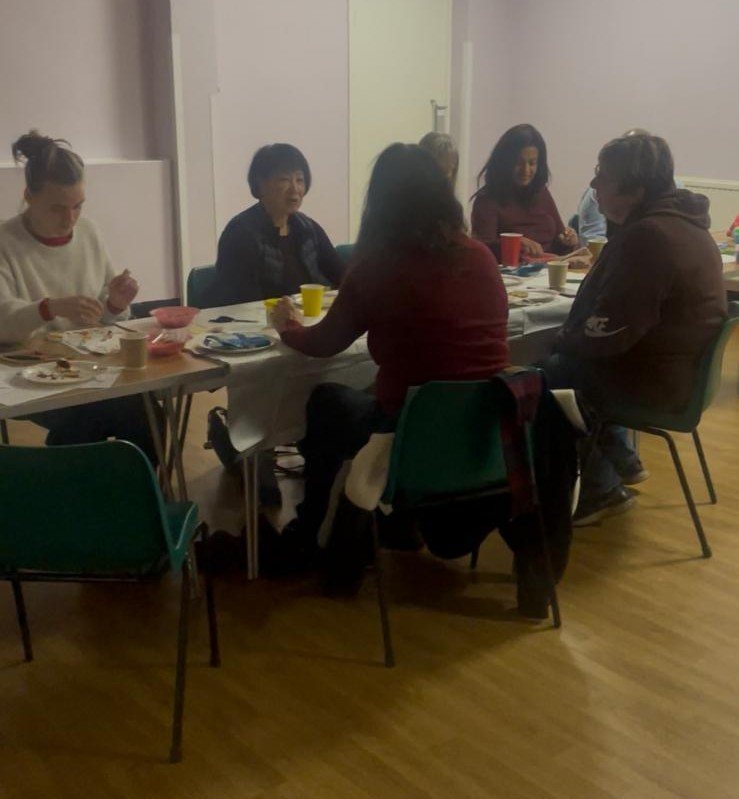 A group talking together around a table at a community gathering.